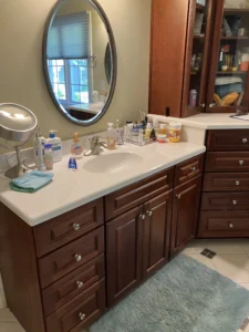 Cluttered vanity with outdated cabinetry and accessories