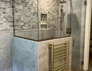 Curb-less shower with pebble niche and brass fixtures
