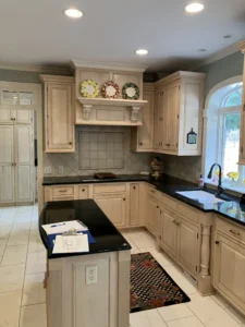 Existing kitchen layout showing original light brown cabinetry, tiled floors, and dated appliances.