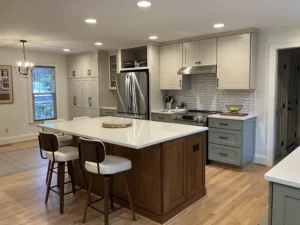 Bright, updated kitchen featuring a large center island with seating, white cabinetry, subway tile backsplash, and stainless steel appliances in a warm, open layout.
